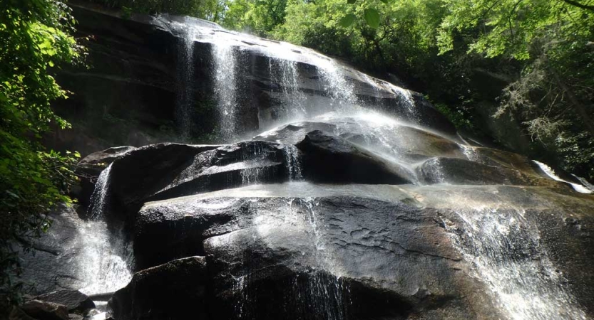 Trickles of water flow over a large rock formation 